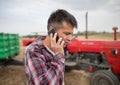 Male agronomist standing in harvested field talking on phone Royalty Free Stock Photo