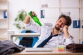 Young alcohol addicted employee sitting in the office