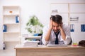 Young alcohol addicted employee sitting in the office