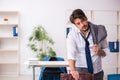 Young alcohol addicted employee sitting in the office