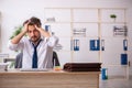 Young alcohol addicted employee sitting in the office