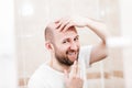 Bald man looking mirror at head baldness and hair loss Royalty Free Stock Photo