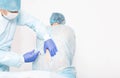 A male anesthesiologist performs a surgical procedure that introduces epidural anesthesia into the back of a girl during