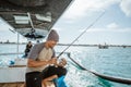 male angler checks a reel on small fishing boat Royalty Free Stock Photo