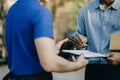 Male appending signature sign on paper for sending boxes with delivery man, Asian man signed with an paper signature on the box,