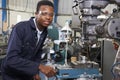 Male Apprentice Engineer Working On Drill In Factory