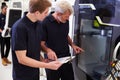 Male Apprentice Working With Engineer On CNC Machinery Royalty Free Stock Photo