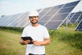 Male arab engineer standing on field with rows of solar panels Royalty Free Stock Photo