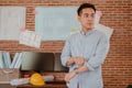 Male architect in formalwear bending working engineering with engineering equipment, blueprint and helmet in office. Royalty Free Stock Photo