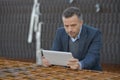 male architect holding tablet pc against building