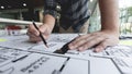 A male architect measuring and marking the scale ratio of sizes of a complicated blueprint