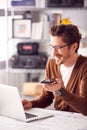 Male Architect In Office Working At Desk On Laptop Taking Speakerphone Call On Mobile Phone Royalty Free Stock Photo