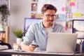 Male Architect In Office Working At Desk Making Online Purchase Using Credit Card On Laptop Royalty Free Stock Photo