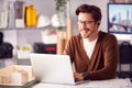 Male Architect In Office Working On Plan At Desk Taking Phone Call On Wireless Earphones Royalty Free Stock Photo