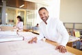 Male Architect Studying Plans In Office