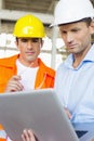 Male architects working on laptop at construction site Royalty Free Stock Photo