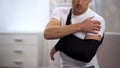 Male in arm sling suffering pain in shoulder, result of work trauma, orthopedics Royalty Free Stock Photo