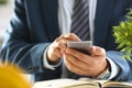 Male arm in suit hold phone and silver pen Royalty Free Stock Photo