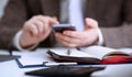 Male arm in suit hold phone and silver pen Royalty Free Stock Photo