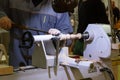 A male artisan works on a wood lathe, curly carving, hobby. The process of manufacturing wooden handicrafts, work space in the