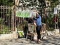 Artist hangs screen prints to dry and display in Place des Abbesses, Montmartre, Paris