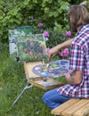Male artist paint on plein air flowers pink peonies painting on nature