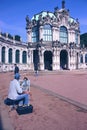 Male artist painting a picture of the museum building