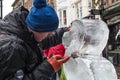 Male artist sculpting and ice scultpure as part of a festival in an outdoor public place