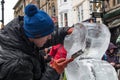 Male artist sculpting and ice scultpure as part of a festival in an outdoor public place