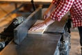 Male artist works with a wooden board at the planer, joiner's sh Royalty Free Stock Photo