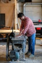 Male artist works with a wooden board at the planer, joiner's sh Royalty Free Stock Photo