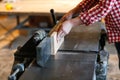 Male artist works with a wooden board at the planer, joiner's sh Royalty Free Stock Photo