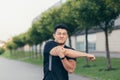 Male asian athlete, kneading shoulder pain, sore arm muscles in the park Royalty Free Stock Photo