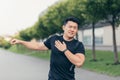 Male asian athlete, kneading shoulder pain, sore arm muscles in the park Royalty Free Stock Photo