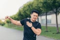 Male asian athlete, kneading shoulder pain, sore arm muscles in the park Royalty Free Stock Photo
