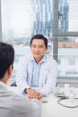 Male asian doctor comforting patient at consulting room Royalty Free Stock Photo