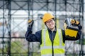 Male Asian mechanic carrying work tool at site