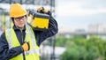 Male Asian mechanic carrying work tool at site Royalty Free Stock Photo