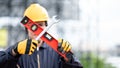 Worker man holding level tool and wrench at site Royalty Free Stock Photo