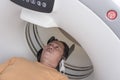 A male asian patient undergoes a CT scan at the clinic