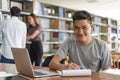 Male asian student studying and reading book in library Royalty Free Stock Photo