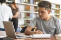 Male asian student studying and reading book in library Royalty Free Stock Photo