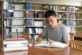Male asian student studying and reading book in library Royalty Free Stock Photo