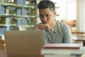 Male asian student studying and reading book in library Royalty Free Stock Photo