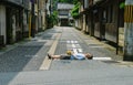 Male tourist lying on epmty urban streets at Kinosaki, Japan