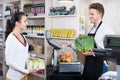 Male assistant helping customer in grocery shop