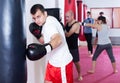 Male athlete beating boxing bag