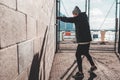 Male athlete boxing against the wall in big urban city