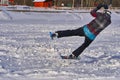 A male athlete engaged in snow kiting on the ice of a large snowy lake. He performs the jump. Winter sunny frosty day. Close-up