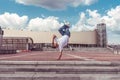 Male athlete, guy dancer summer city. Standing one arm jump. Fashionable modern break dance style fast, fitness sport Royalty Free Stock Photo
